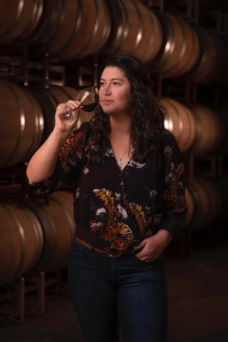 Abigail Horstman Estrada leaning holding wine