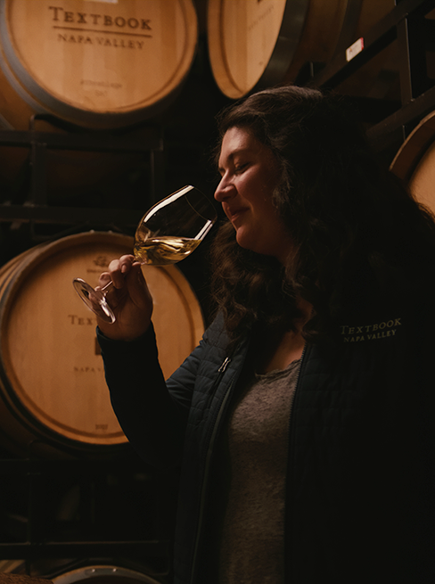 Abigail Horstman Estrada in cellar tasting Chardonnay