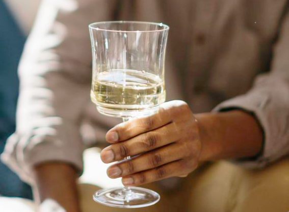 Man holding glass of white wine